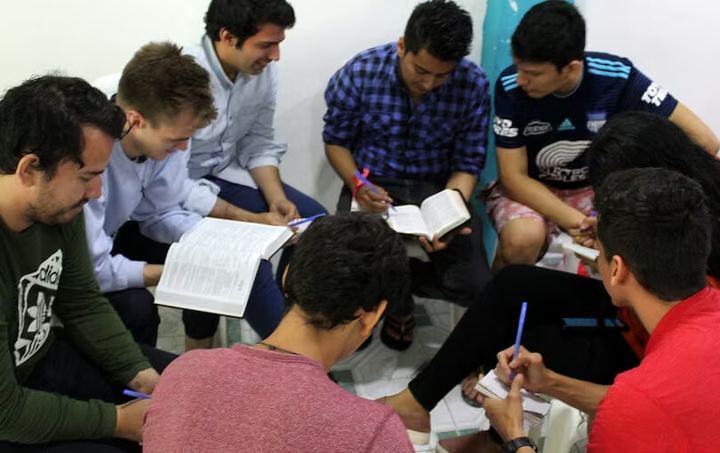 Students studying the Bible together around a table