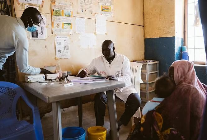 A health worker seeing patients in a clinic room