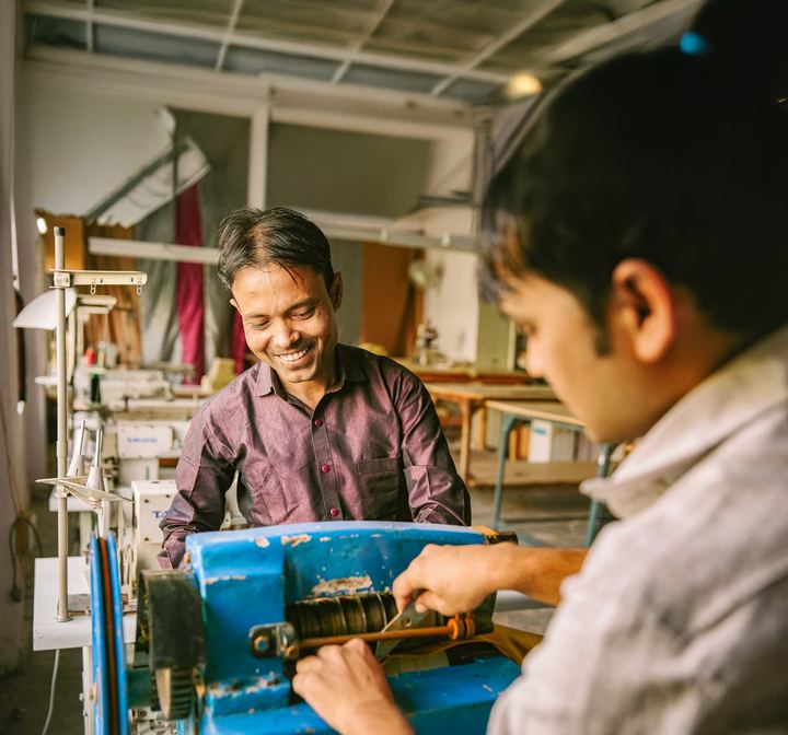 A trainer and a young man working together at a machine
