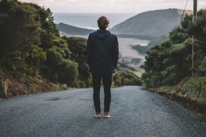 A person walking along a road between hills